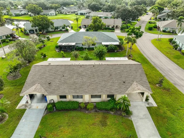 an aerial view of a house with a garden and lake view