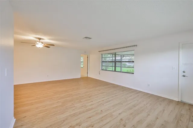 a view of a room with wooden floor chandelier and windows
