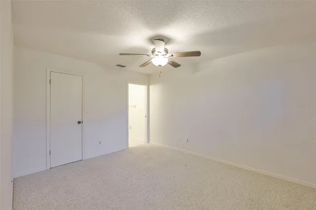an empty room with a ceiling fan and a window