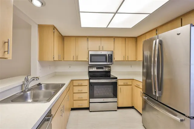 a kitchen with stainless steel appliances granite countertop a refrigerator sink and stove