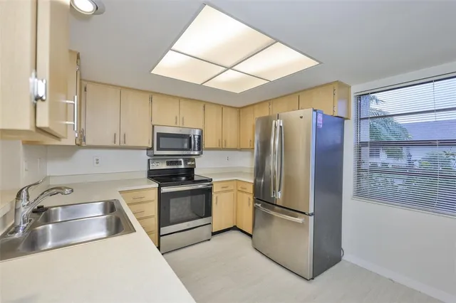 a kitchen with a sink stainless steel appliances and cabinets
