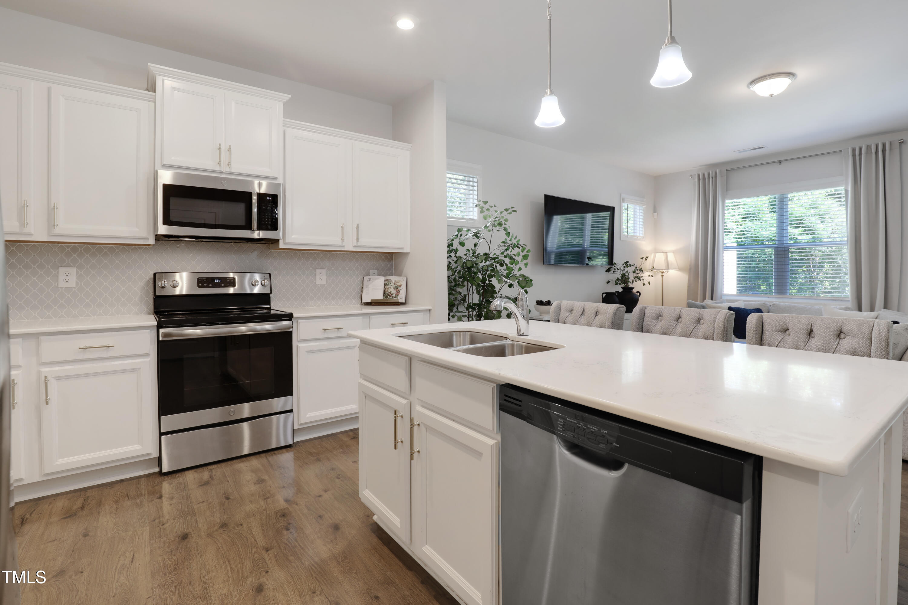 3636 Water Mist Lane Raleigh, NC 27604 - Photo 12 of 28 a kitchen with stainless steel appliances a sink a stove a microwave a center island and cabinets