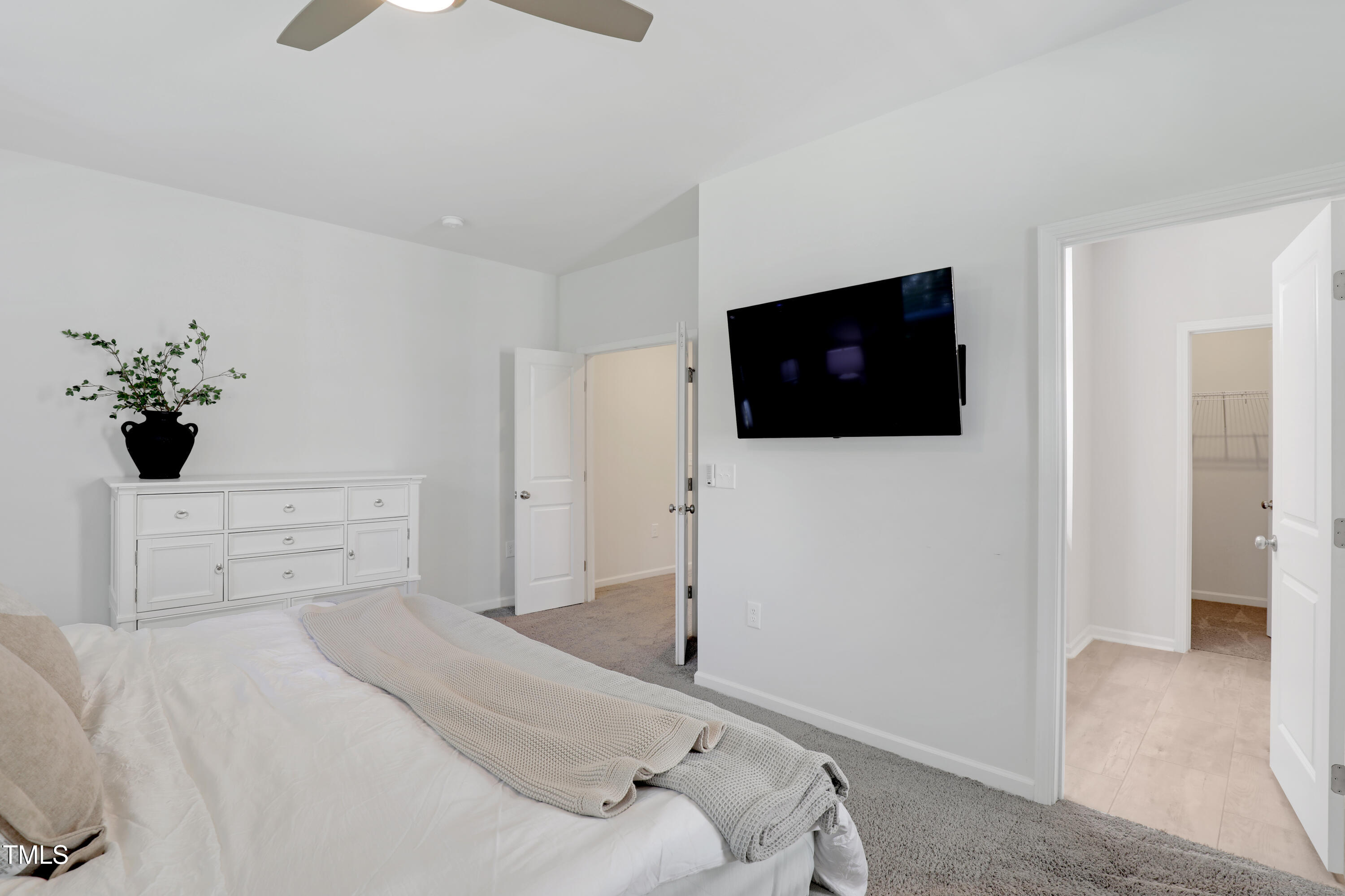 3636 Water Mist Lane Raleigh, NC 27604 - Photo 18 of 28 a bedroom with a bed a mirror and a flat screen tv