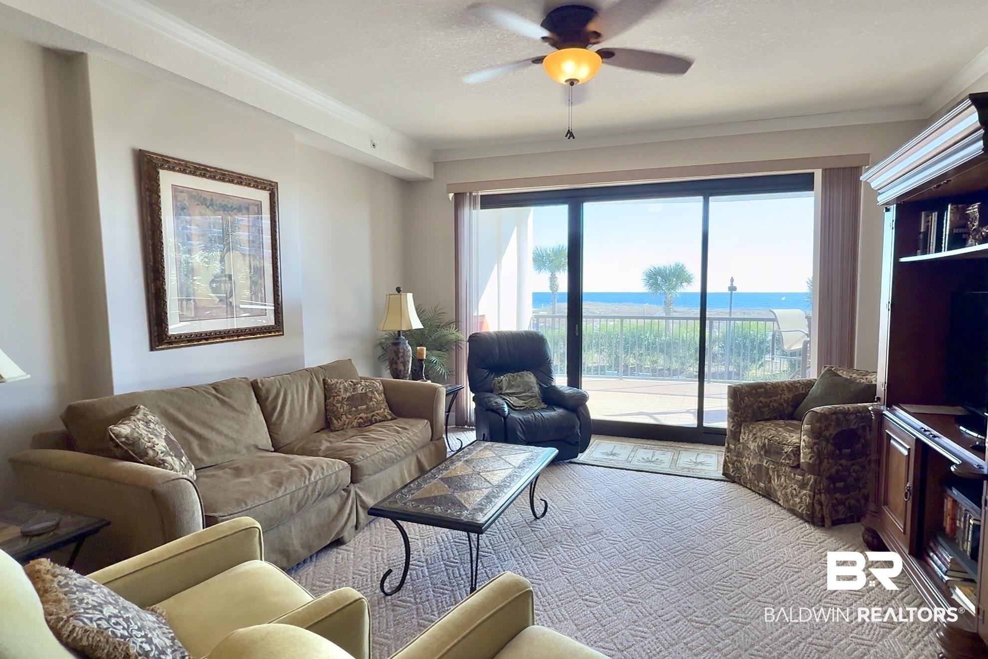 27284 Gulf Road, Unit 212 Orange Beach, AL 36561 - Photo 2 of 35 Living area with a ceiling fan, crown molding, and carpet floors