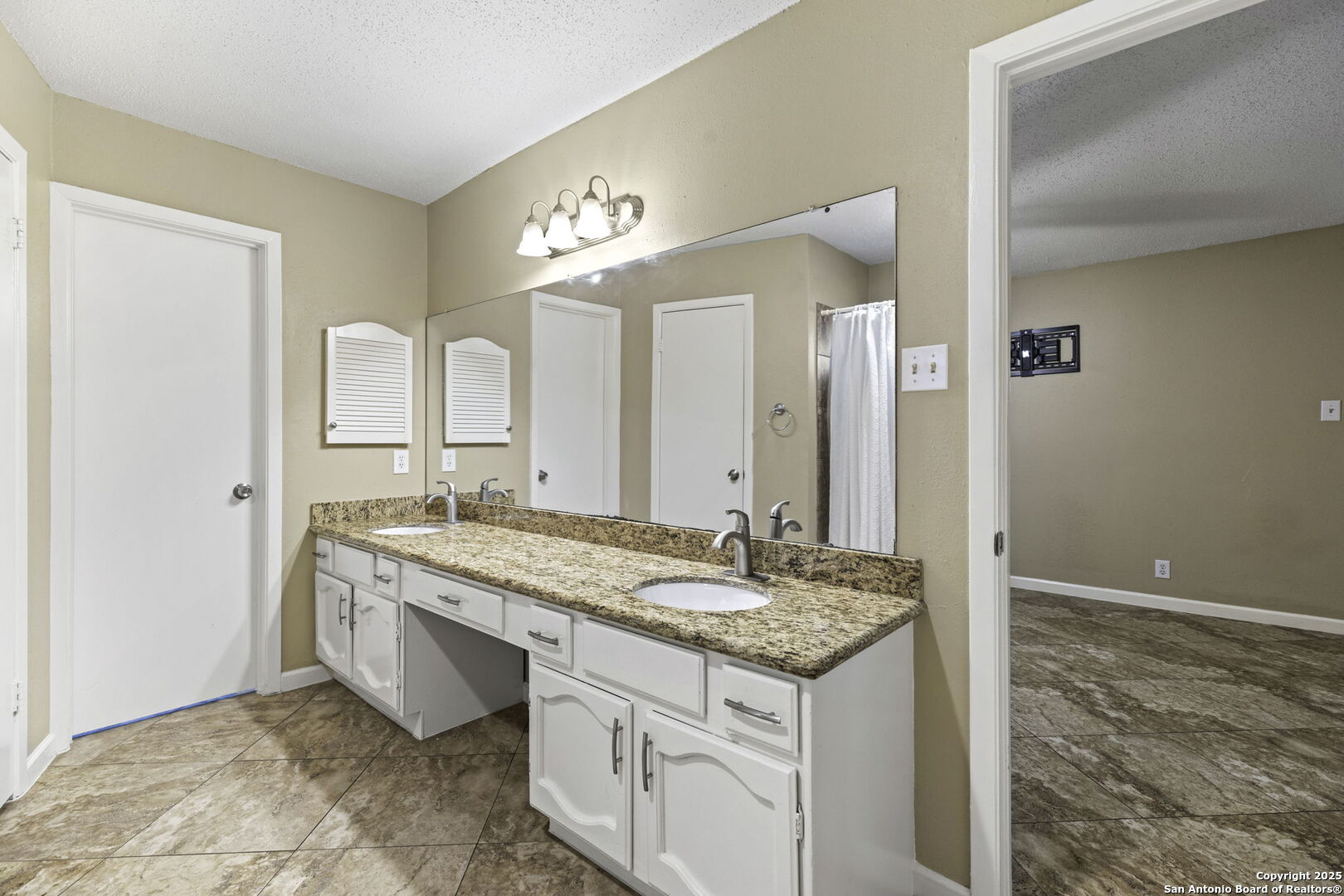 5346 Binz Engleman Road Kirby, TX 78219 - Photo 17 of 28 a bathroom with a granite countertop sink and a mirror