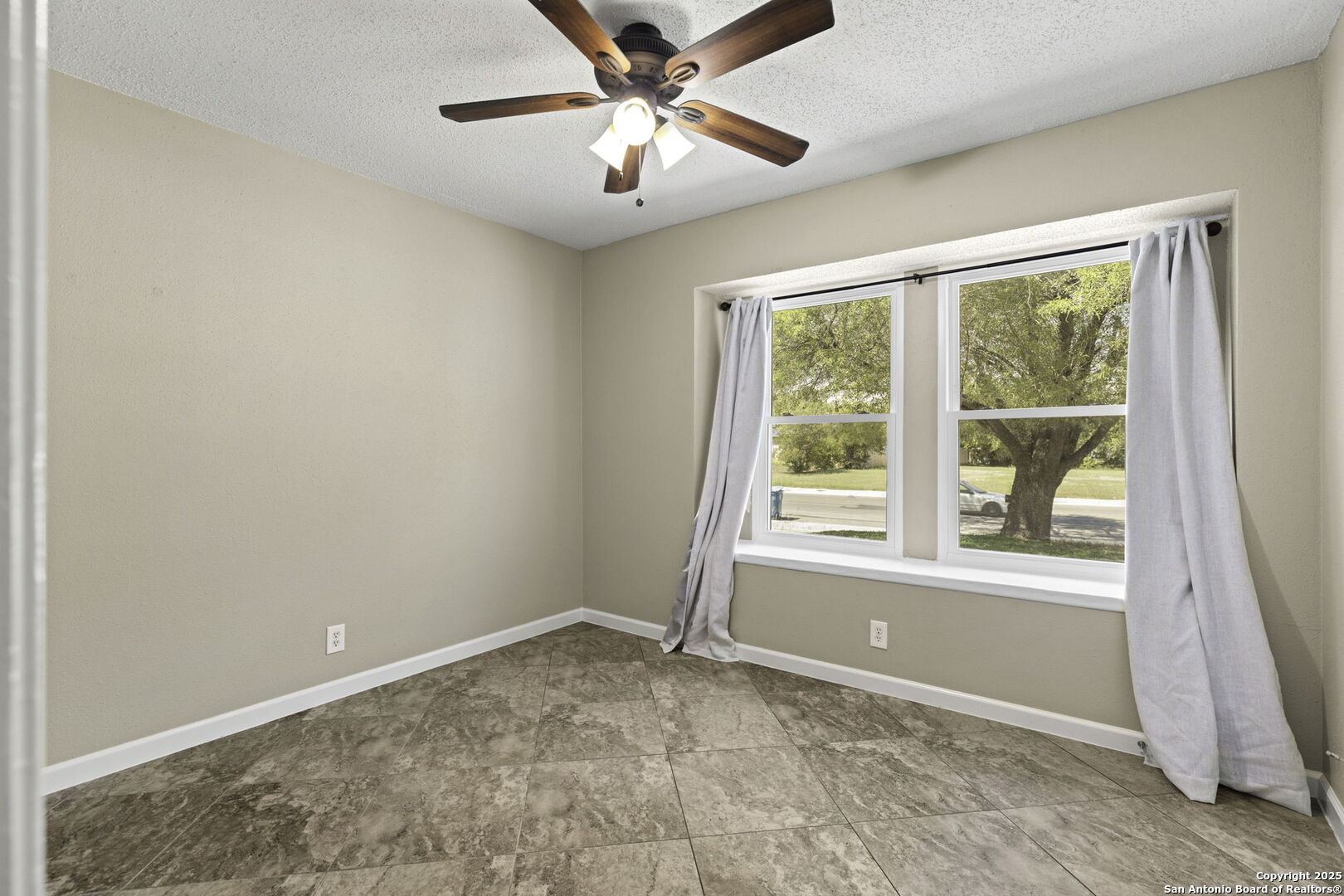 5346 Binz Engleman Road Kirby, TX 78219 - Photo 22 of 28 a view of a big room with windows and chandelier fan