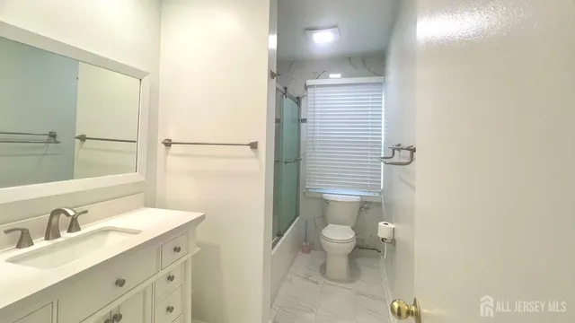 a bathroom with a sink a toilet a shower and a mirror