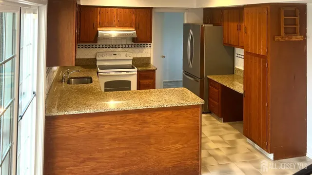 a kitchen with granite countertop a refrigerator and a stove