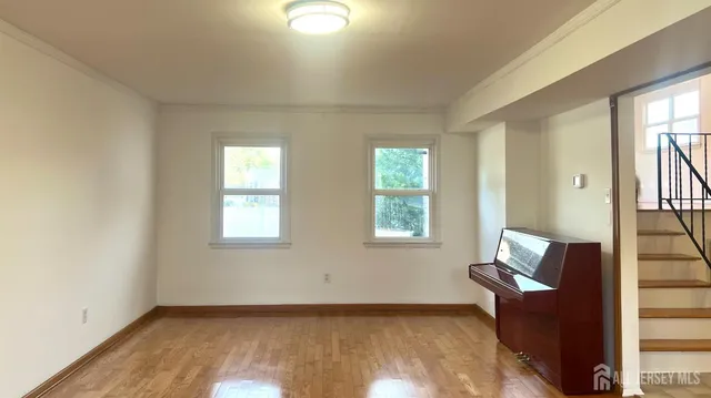 an empty room with windows and wooden floor