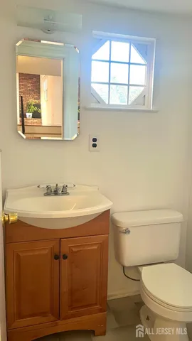 a bathroom with a toilet a sink and a window