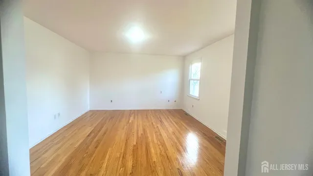 a view of a room with wooden floor and window