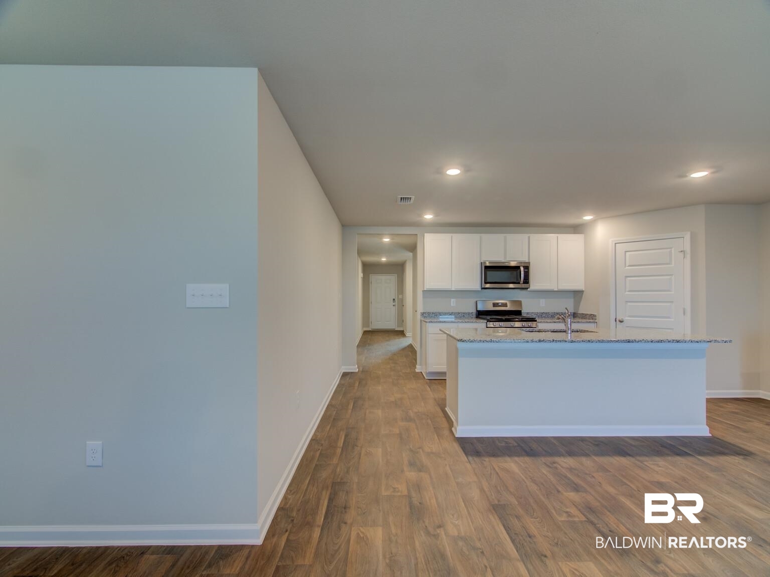 23952 Citation Loop Daphne, AL 36526 - Photo 21 of 69 Kitchen with white cabinetry, light stone counters, dark wood-style flooring, an island with sink, and stainless steel appliances