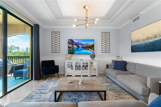 a living room with furniture a chandelier and a large window