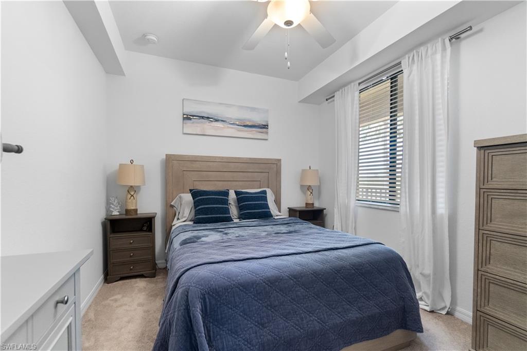 9590 Trevi Court, Unit 5337 Naples, FL 34113 - Photo 11 of 14 a bedroom with a bed and a fireplace