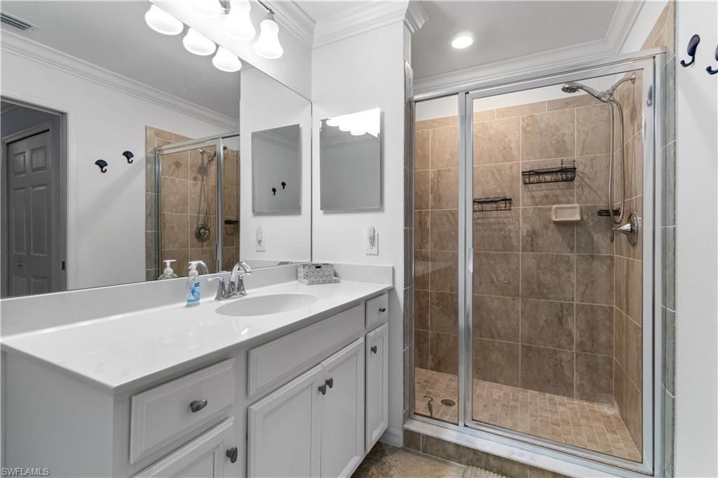 9590 Trevi Court, Unit 5337 Naples, FL 34113 - Photo 12 of 14 a bathroom with a shower sink and mirror