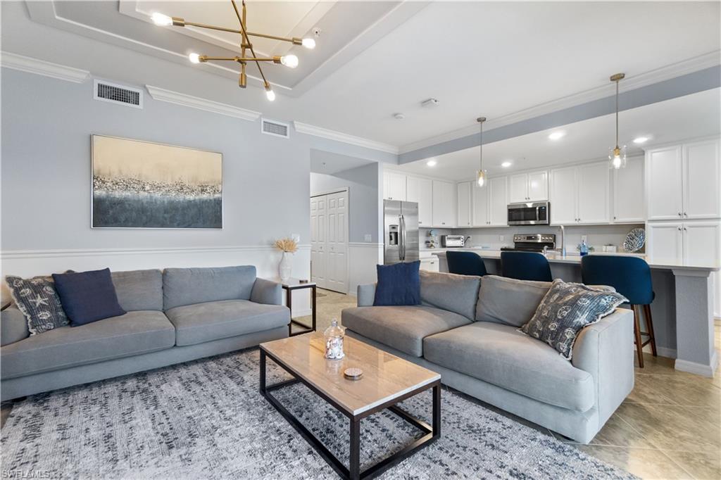 9590 Trevi Court, Unit 5337 Naples, FL 34113 - Photo 3 of 14 a living room with furniture and kitchen view