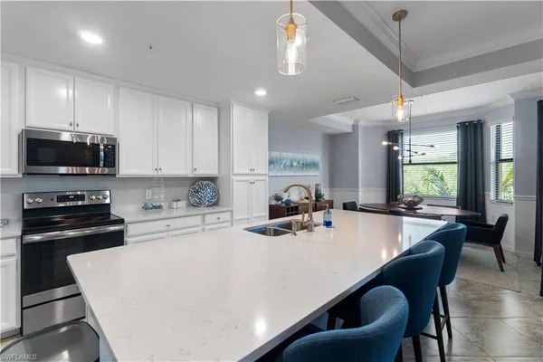 a kitchen with sink a stove and chairs