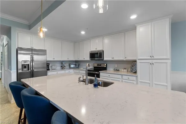 a kitchen with refrigerator a stove a sink cabinets and a counter top space