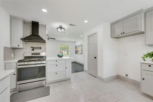 a kitchen with white cabinets and appliances
