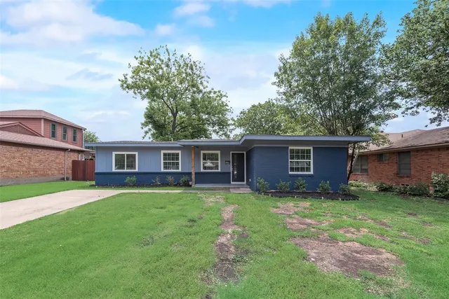a view of a yard in front of a house with large trees