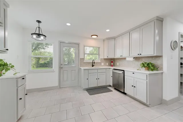 a kitchen with white cabinets and white appliances