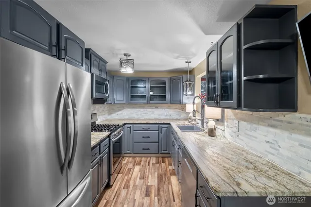 a kitchen with granite countertop cabinets stainless steel appliances and a sink