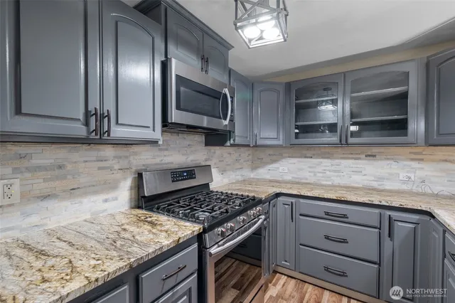 a view of a room with wooden floor fireplace and windows