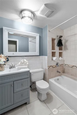 a bathroom with a granite countertop sink a toilet and bathtub