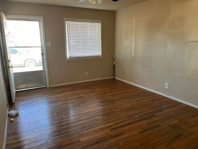 a view of empty room with wooden floor