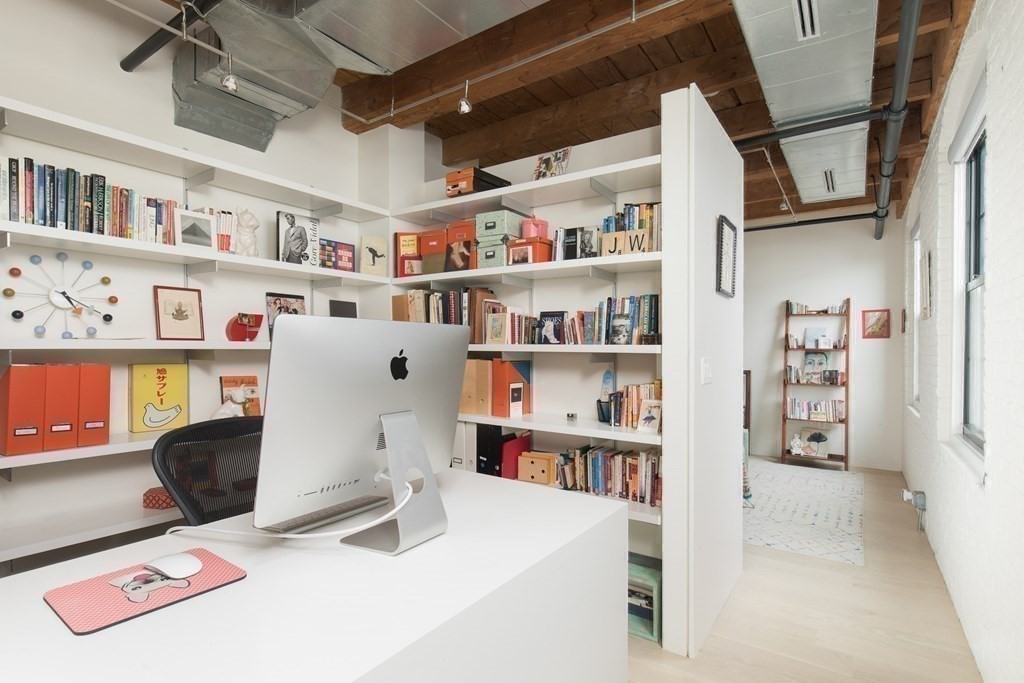 1 Tannery Brook Row, Unit 2A Somerville, MA 02144 - Photo 13 of 18 a room with lots of books and knick knacks on it