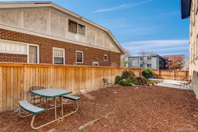 a backyard of a house with table and chairs