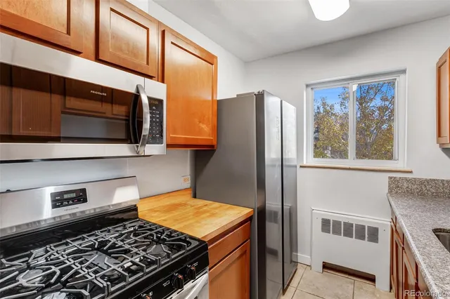a kitchen with stainless steel appliances granite countertop a stove microwave and refrigerator