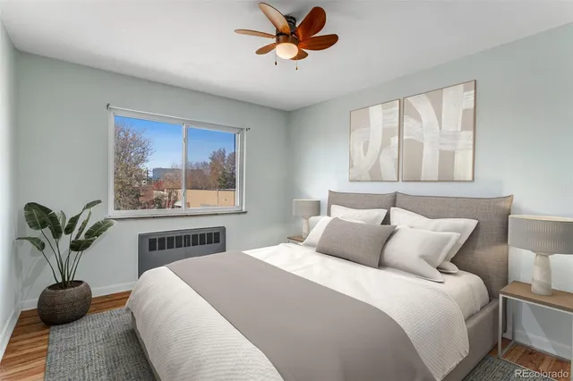 a bedroom with a large bed and a potted plant