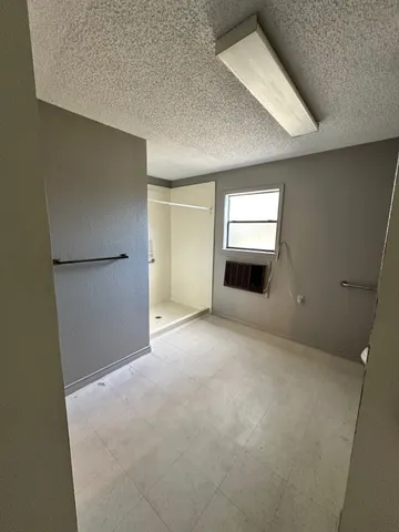 a view of an empty room with a kitchen