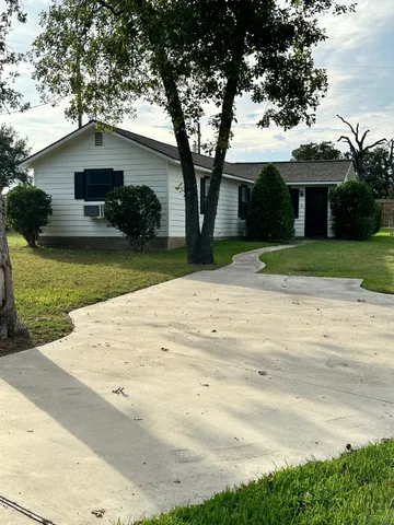 a front view of a house with a yard and potted plants