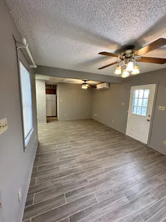 a view of empty room with window and wooden floor