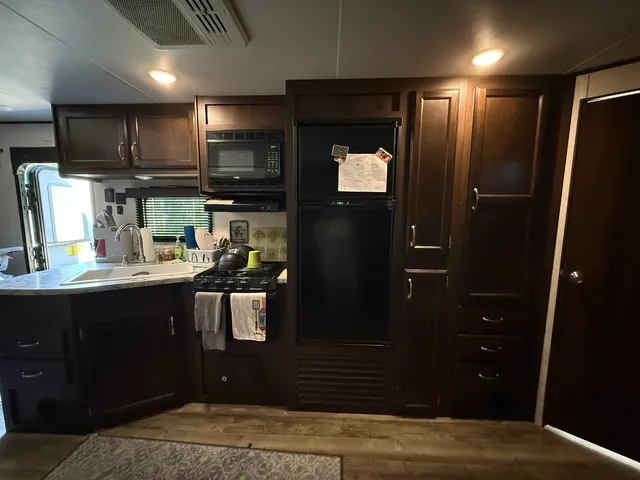 a kitchen with stainless steel appliances granite countertop a refrigerator and a sink