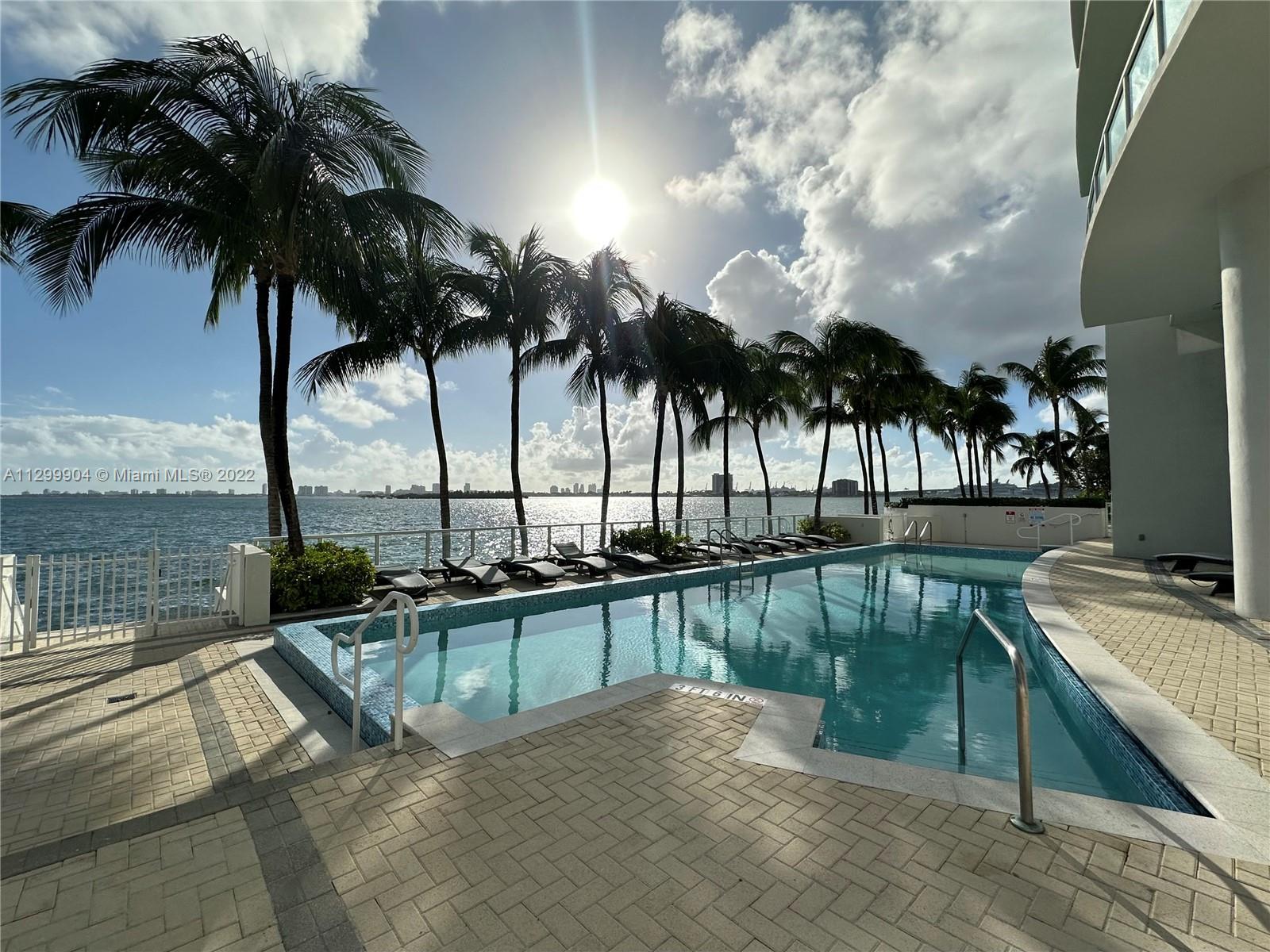 665 Northeast 25th Street, Unit 2104 Miami, FL 33137 - Photo 20 of 38 a view of a swimming pool with a table and chairs