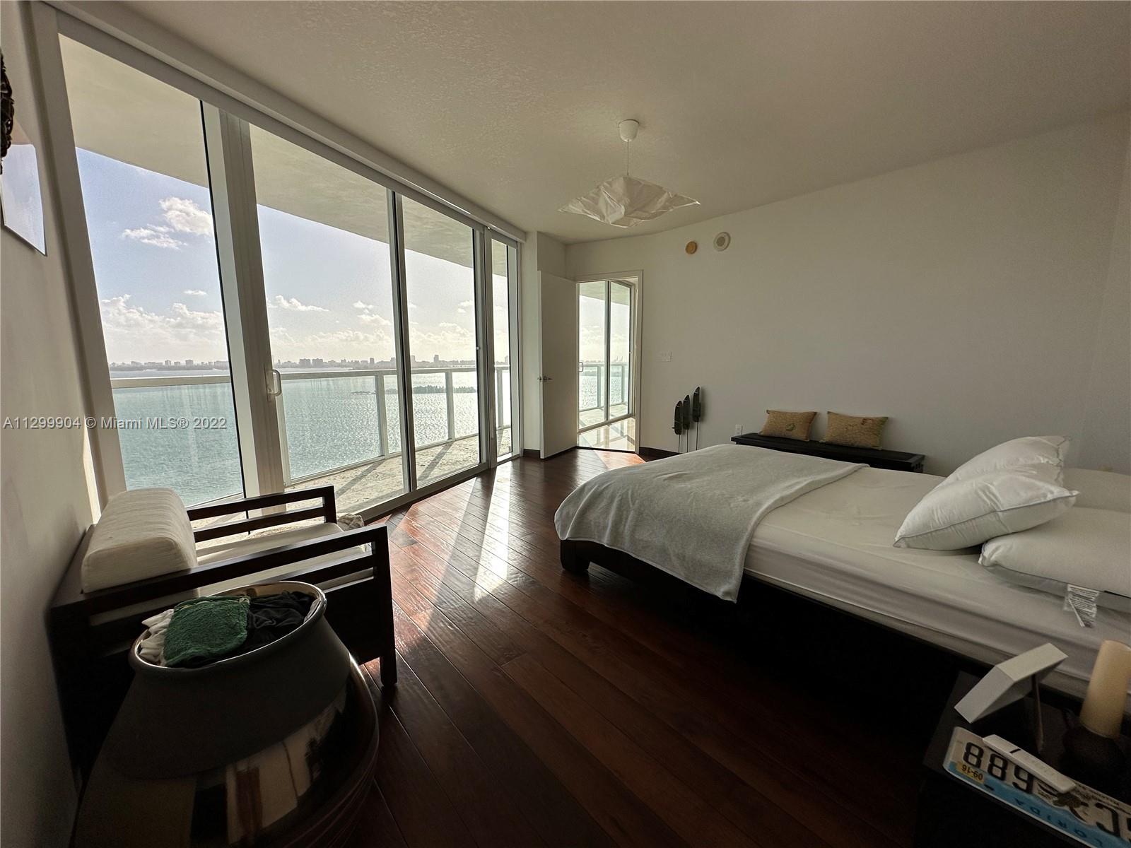 665 Northeast 25th Street, Unit 2104 Miami, FL 33137 - Photo 2 of 38 a bedroom with a bed and wooden floor
