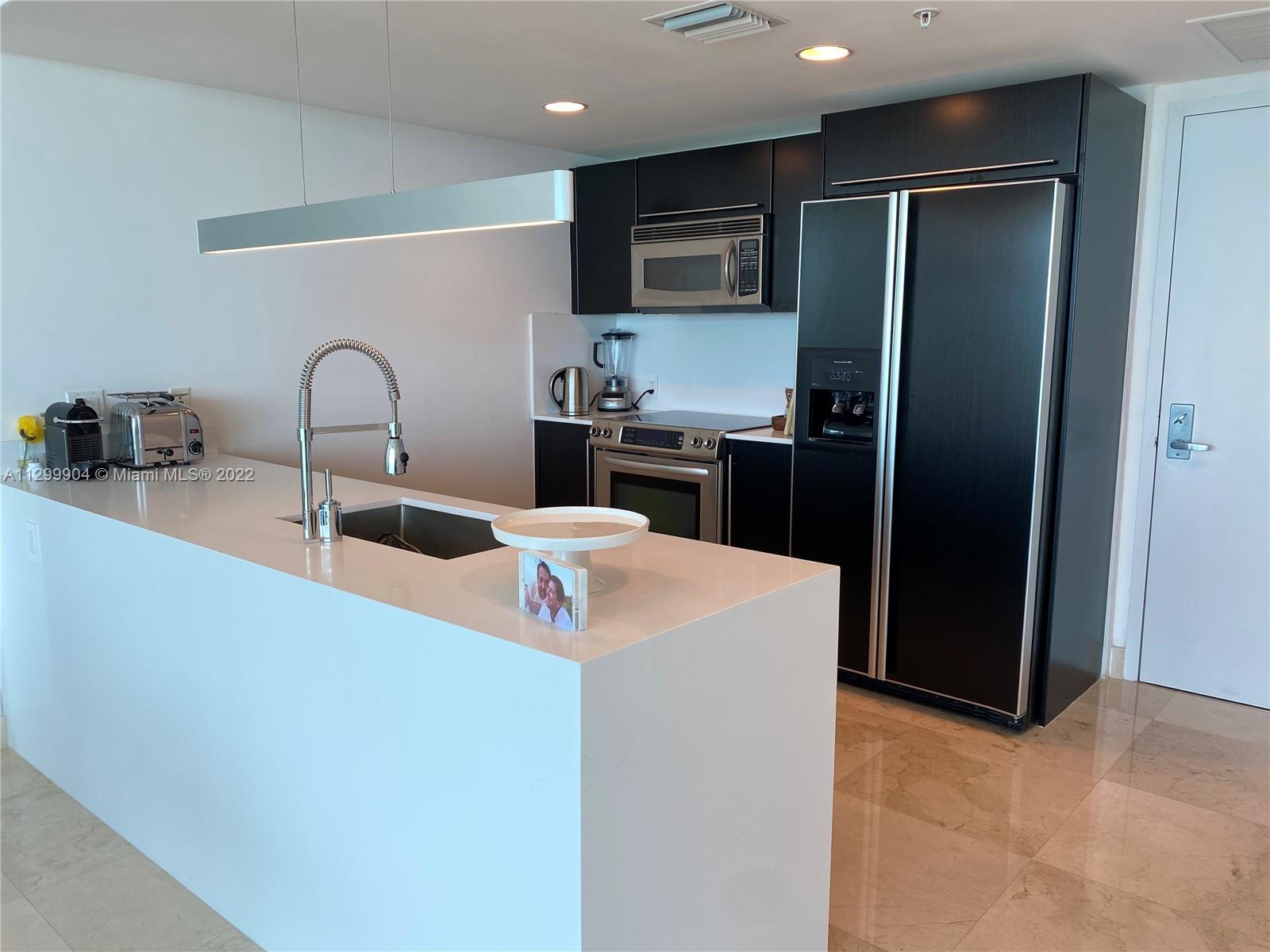 665 Northeast 25th Street, Unit 2104 Miami, FL 33137 - Photo 9 of 38 a kitchen with stainless steel appliances granite countertop a refrigerator and a sink