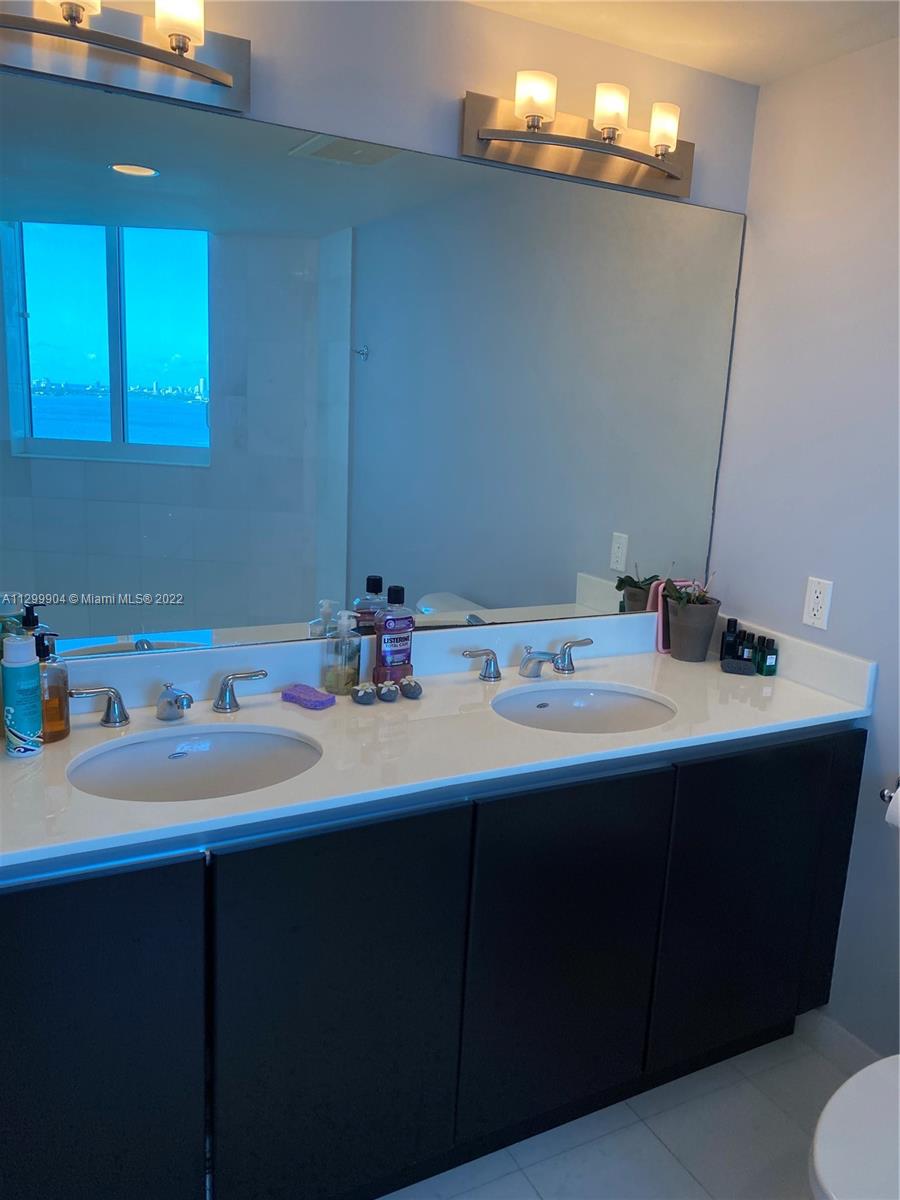 665 Northeast 25th Street, Unit 2104 Miami, FL 33137 - Photo 10 of 38 a bathroom with a sink and a mirror