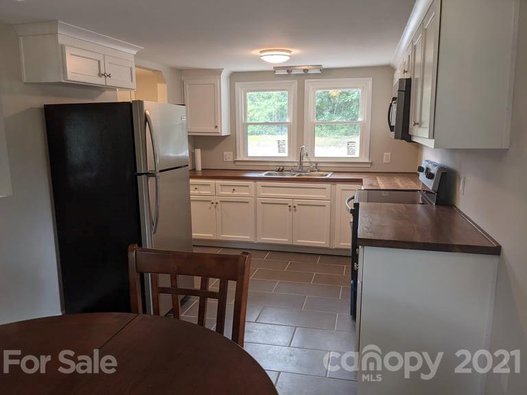 2271 West Chester School Road Chester, SC 29706 - Photo 7 of 19 a kitchen with a sink a refrigerator and black cabinets