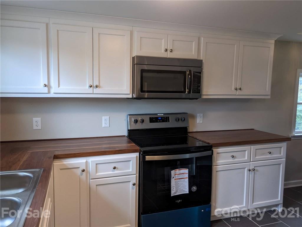 2271 West Chester School Road Chester, SC 29706 - Photo 8 of 19 a kitchen with white cabinets and black appliances