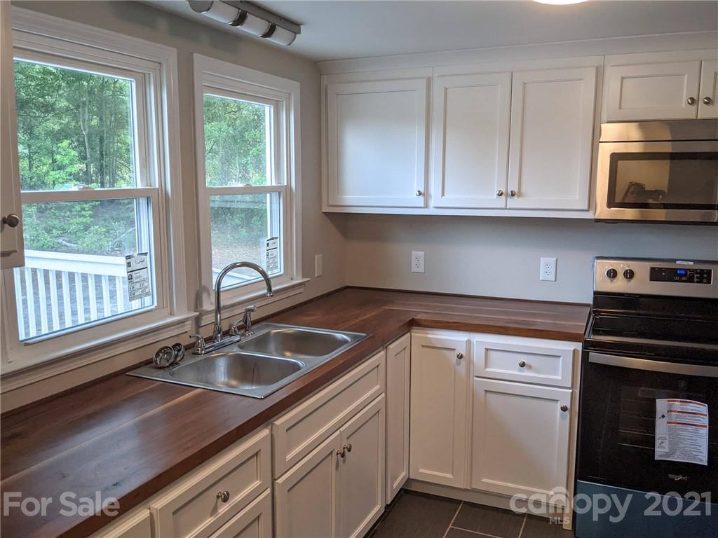 2271 West Chester School Road Chester, SC 29706 - Photo 9 of 19 a kitchen with stainless steel appliances granite countertop a sink stove and window