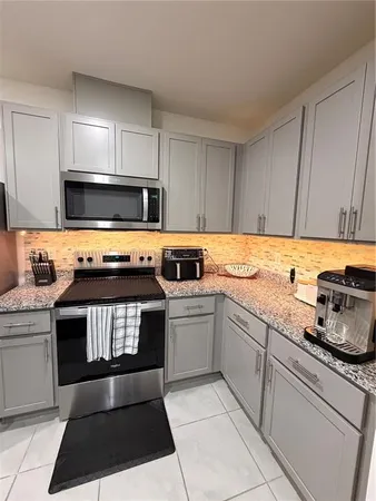 a kitchen with stainless steel appliances granite countertop a stove a sink and a microwave