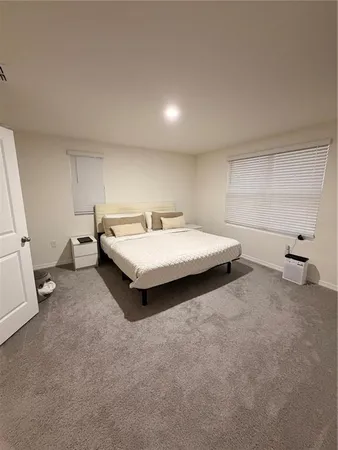 a spacious bedroom with a bed and a large window