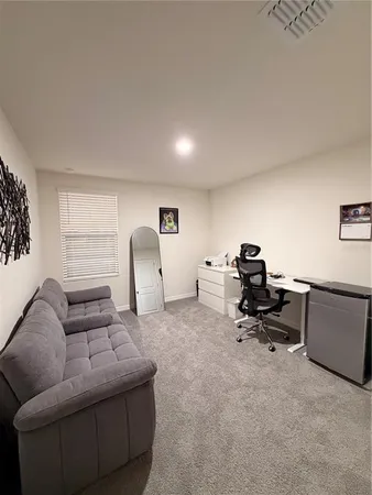 a view of a workspace with furniture and a window