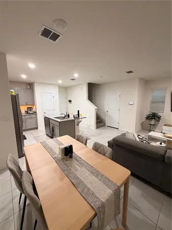 a living room with furniture and a view of kitchen