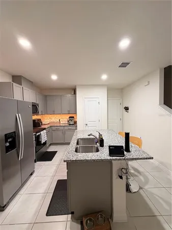 a kitchen that has a lot of cabinets a sink and appliances in it