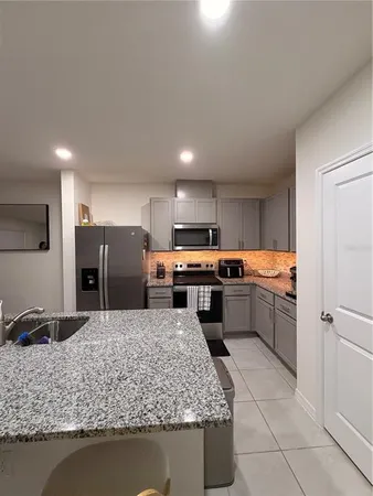 a kitchen with a sink refrigerator and microwave